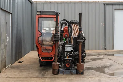 2016 Ditch Witch JT25 rear view showing enclosed cab, drill frame, pipe rack with loaded drill pipe, hydraulic rotary head