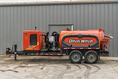 2023 Ditch Witch HX75 mud recycler, full driver-side profile, tandem-axle trailer, orange vacuum tank, engine module, hose connections visible