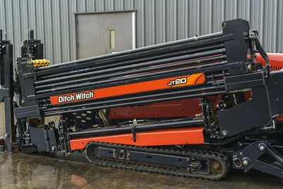 2015 Ditch Witch JT20 HDD drill, side view showing loaded drill pipe rack, carriage, rubber tracks, orange frame