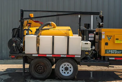 2024 Vermeer LP573SGT vacuum excavator, side profile view showing spoil tank, water tanks, boom assembly, and tandem axles.