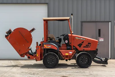 Side profile of 2017 Ditch Witch RT80 trencher with rear attachment, canopy, open operator station, and front blade.
