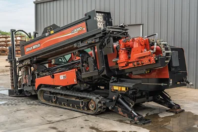 2012 Ditch Witch JT3020 Mach 1 HDD rig, side profile, showing drill carriage, steel tracks, and hydraulic stabilizer legs.