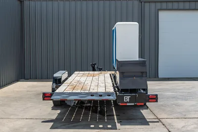 2026 Behnke TBCT2220ET-BT-R HDD trailer, rear view, wood deck, diamond-plate ramps, toolbox, blue/white enclosure, BT branding