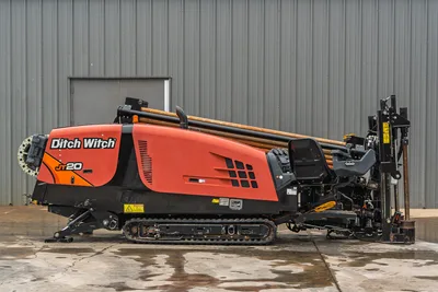 Profile view of 2018 Ditch Witch JT20 HDD drill with rubber tracks, engine cowling, control console, and drill pipe rack.