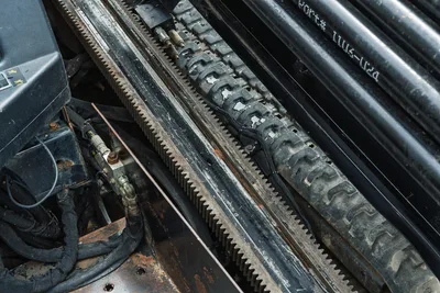 Ditch Witch JT10 rack and pinion gear drive system, drill pipe carriage, and internal hydraulic lines detail.