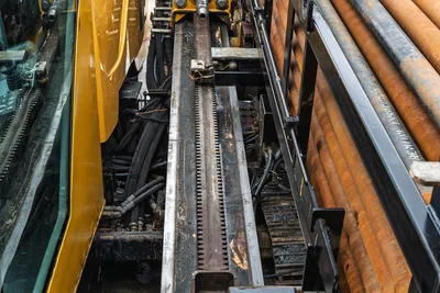 Overhead view of 2017 Vermeer 40x55 S3 drill rack, gear track, hydraulic lines, operator cab glass, and drill rod box.