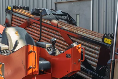 2021 Ditch Witch JT28 operator station with joystick controls, worn drill pipe rack loaded with 2.375" HDD pipe, close-up angle