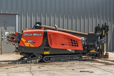 2023 Ditch Witch JT20 HDD drill, driver-side view, orange hood, drill pipe loaded, carriage assembly, rubber tracks, vise visible