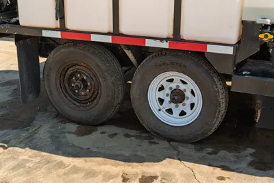 2024 Vermeer LP573SGT mud trailer tandem axle assembly, Carlstar tires, white and steel wheels, side fluid tank detail.