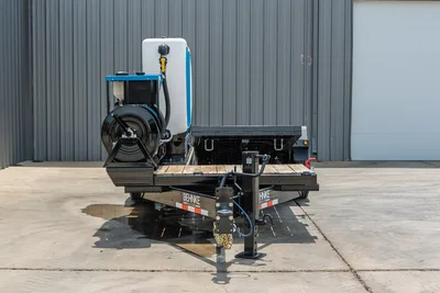 Behnke TBCT2220ET-BT-R HDD trailer front view showing tongue, jack stand, hose reel, white poly tank, and blue mud mixing unit