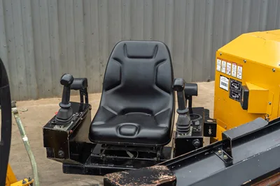 2018 Vermeer D8x12 operator seat with dual joystick controls, armrests, and yellow engine housing visible at right