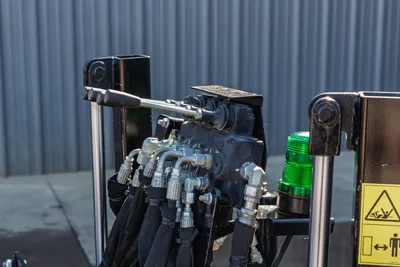 Ditch Witch JT10 engine compartment detail, rotary drive shaft, hydraulic manifold, warning beacon, drill pipe attachment