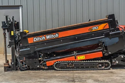 2021 Ditch Witch JT20 HDD drill, side view showing angled drill frame, rubber tracks, hydraulic thrust cylinders, and drill pipe loaded