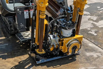 2021 Vermeer D8x12 drill carriage close-up showing spindle, hydraulic lines, fluid filter, and drill rod loaded on rack