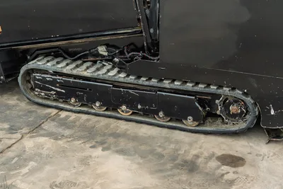 2018 Vermeer D8x12 rubber track close-up showing undercarriage rollers, drive sprocket, hydraulic lines, wear marks visible
