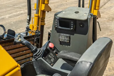 Vermeer 10x15 S3 cab interior with digital display, control panel, joystick, and drill pipe assembly visible from operator perspective