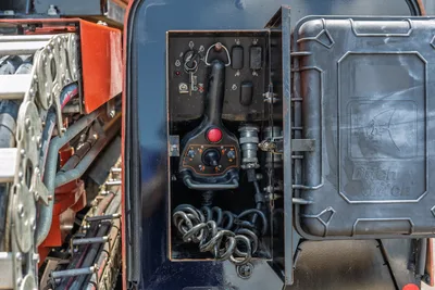 2023 Ditch Witch JT20 open control panel showing joystick, switches, hydraulic fittings, coiled cable, and Ditch Witch badged access door