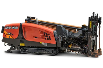 2023 Ditch Witch JT20 HDD drill, 3/4 side view, orange cab, rubber tracks, loaded drill pipe rack, rear carriage assembly visible