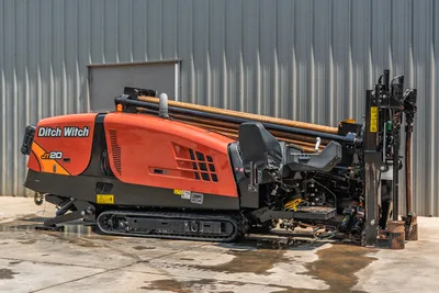 2023 Ditch Witch JT20 HDD rig, 3/4 side view, orange hood, rubber tracks, loaded drill pipe rack, carriage assembly visible