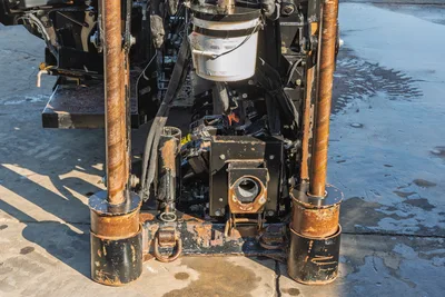 Front view of Ditch Witch JT20 drill frame featuring dual anchors, wrench assembly, and centralized mud motor components.