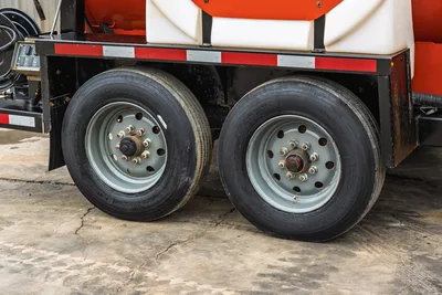 Side profile of 2019 Ditch Witch HX30 mud vacuum trailer showing tandem axles, steel wheels, and white storage tanks.