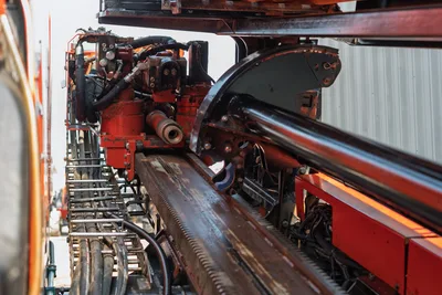 2017 Ditch Witch JT30 drill frame close-up showing thrust rack, carriage, hydraulic lines, and spindle assembly with wear patina