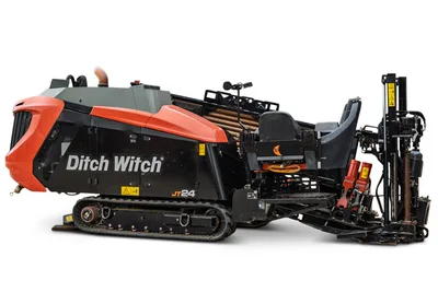2024 Ditch Witch JT24 HDD drill, 3/4 right side view, rubber tracks, loaded drill pipe rack, operator seat, and exposed drill carriage visible.