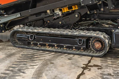Close-up side view of 2021 Ditch Witch AT40 rubber track carriage, drive sprocket, and undercarriage hydraulic components.