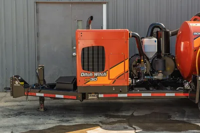 2022 Ditch Witch HX30 mud mixer on trailer, side view, orange engine enclosure, exhaust stack, pump assembly, debris tank visible