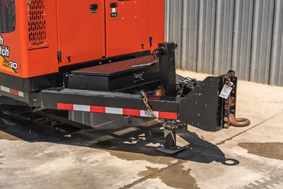 2023 Ditch Witch HX30 trailer hitch end showing pintle ring, safety chains, tongue jack, toolbox, and DOT reflective tape