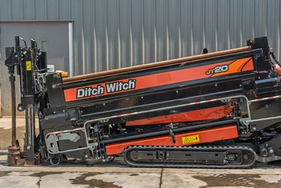 2023 Ditch Witch JT20 HDD drill, side view, drill frame angled down, drill pipe loaded, rubber tracks, hydraulic vise visible