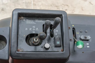 Close-up of Ditch Witch RT80 operator control console showing gear levers, throttle dial, and steering controls in good state.