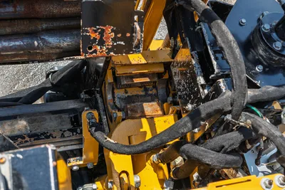 2021 Vermeer D8x12 drill head carriage close-up showing spindle, hydraulic hoses, rust wear, and stacked drill pipe