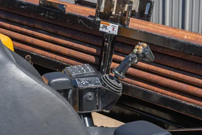 Vermeer D40x55 S3 operator controls: joystick, function keypad, armrest; loaded drill pipe rack visible behind operator station
