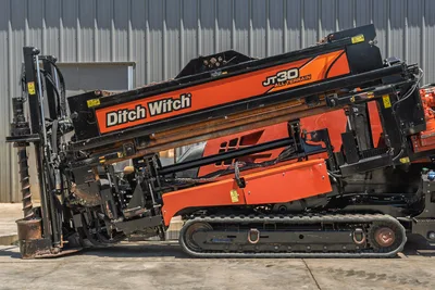 2018 Ditch Witch JT30 All Terrain HDD drill, side view, drill frame angled up, drill pipe loaded, rubber tracks, hydraulic components visible