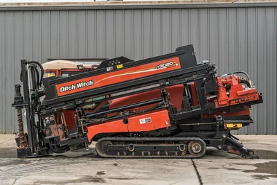 2012 Ditch Witch JT3020 Mach 1 HDD drill, side profile showing rack, carriage, tracks, engine housing, and drill pipe.