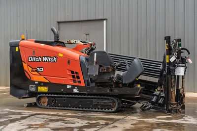 2018 Ditch Witch JT10 horizontal directional drill, side profile view with tracks, operator seat, and drill pipe rack.