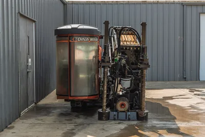 2017 Ditch Witch JT30 HDD drill, rear view showing operator cab, loaded drill pipe rack, vise assembly, and hydraulic components