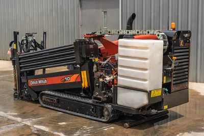 2018 Ditch Witch JT10 HDD drill, rear-quarter view, showing tracks, fluid tank, drill pipe rack, and engine compartment.