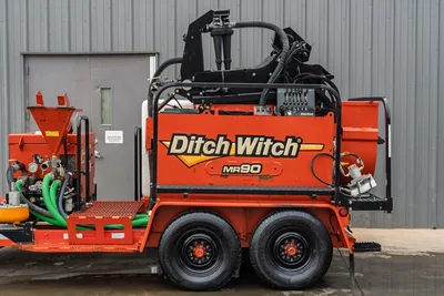 2015 Ditch Witch MR90 mud recycler, side profile, tandem-axle trailer, orange tank, green suction hoses, hydraulic lines, hopper visible left