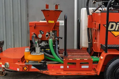 2015 Ditch Witch MR90 mud mixer hopper, pump manifold, pressure gauges, green suction hose, orange strainer, and water tank on trailer