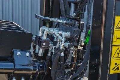 Close-up of hydraulic control manifold and plumbing on a Ditch Witch JT20 HDD drill rig, showing hoses and levers.