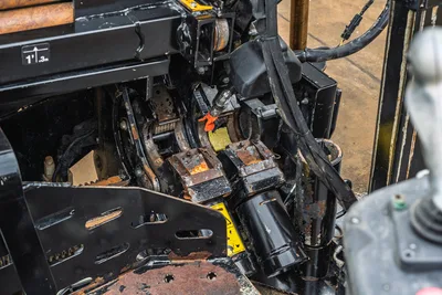 Ditch Witch JT20 drill head assembly, rotary table, and hydraulic manifold, angled top-down view showing operational wear and weathering