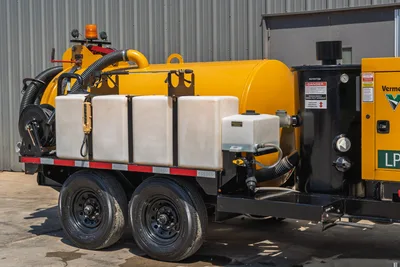 2025 Vermeer LP873SDT vacuum excavator trailer, side view showing yellow debris tank, white water tanks, hose reel, dual axle, and black separator unit.