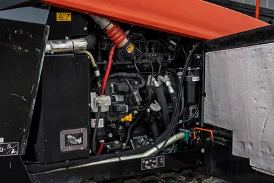 2021 Ditch Witch JT40 engine compartment open, showing 165hp diesel engine, hydraulic lines, exhaust, and fuel filters