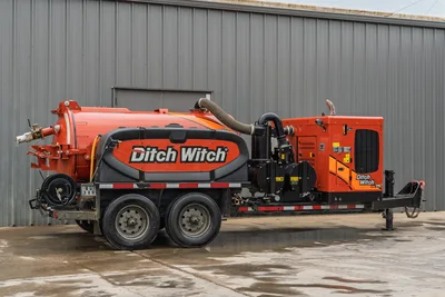 2023 Ditch Witch HX75 mud recycler, trailer-mounted, full driver-side view, orange vacuum tank, engine enclosure, dual axle