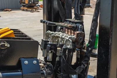 2021 Ditch Witch JT20 hydraulic valve block with control lever, multiple hose fittings, and wrapped hydraulic lines, close-up view