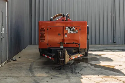 2022 Ditch Witch HX30 mud recycler, rear view on trailer, orange enclosure with ventilation louvers, mixing tank, flex hoses visible