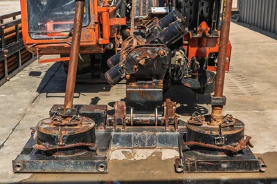 2014 Ditch Witch JT100 Mach 1 drill frame front view showing vise assembly, pipe spinner, anchor plates with heavy wear and surface rust