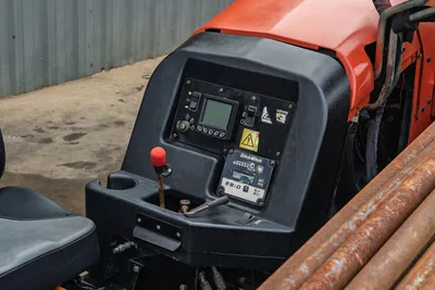 2016 Ditch Witch JT9 operator console with LCD display, ESID locator panel, joystick, seat, and used drill pipe visible